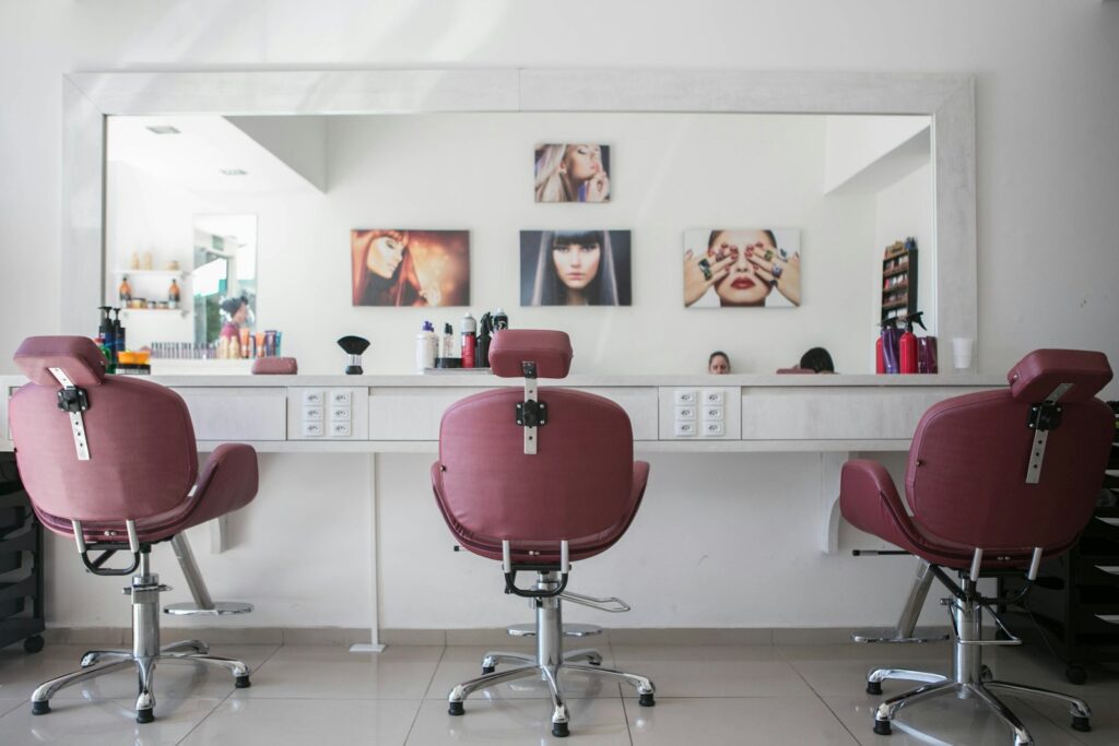 Interior de la peluquería con sillones y espejo